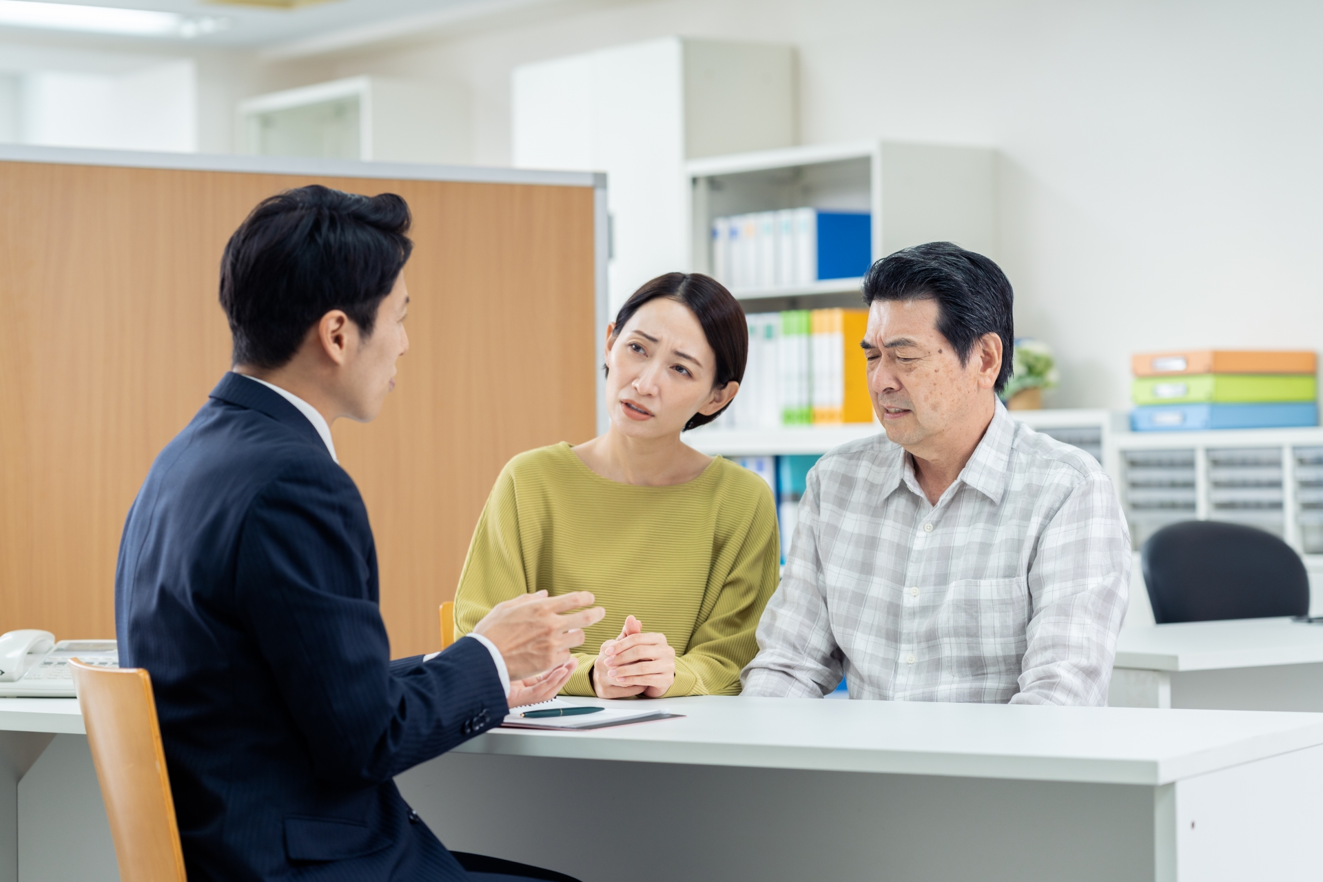 スーツの男性に相談をする男女