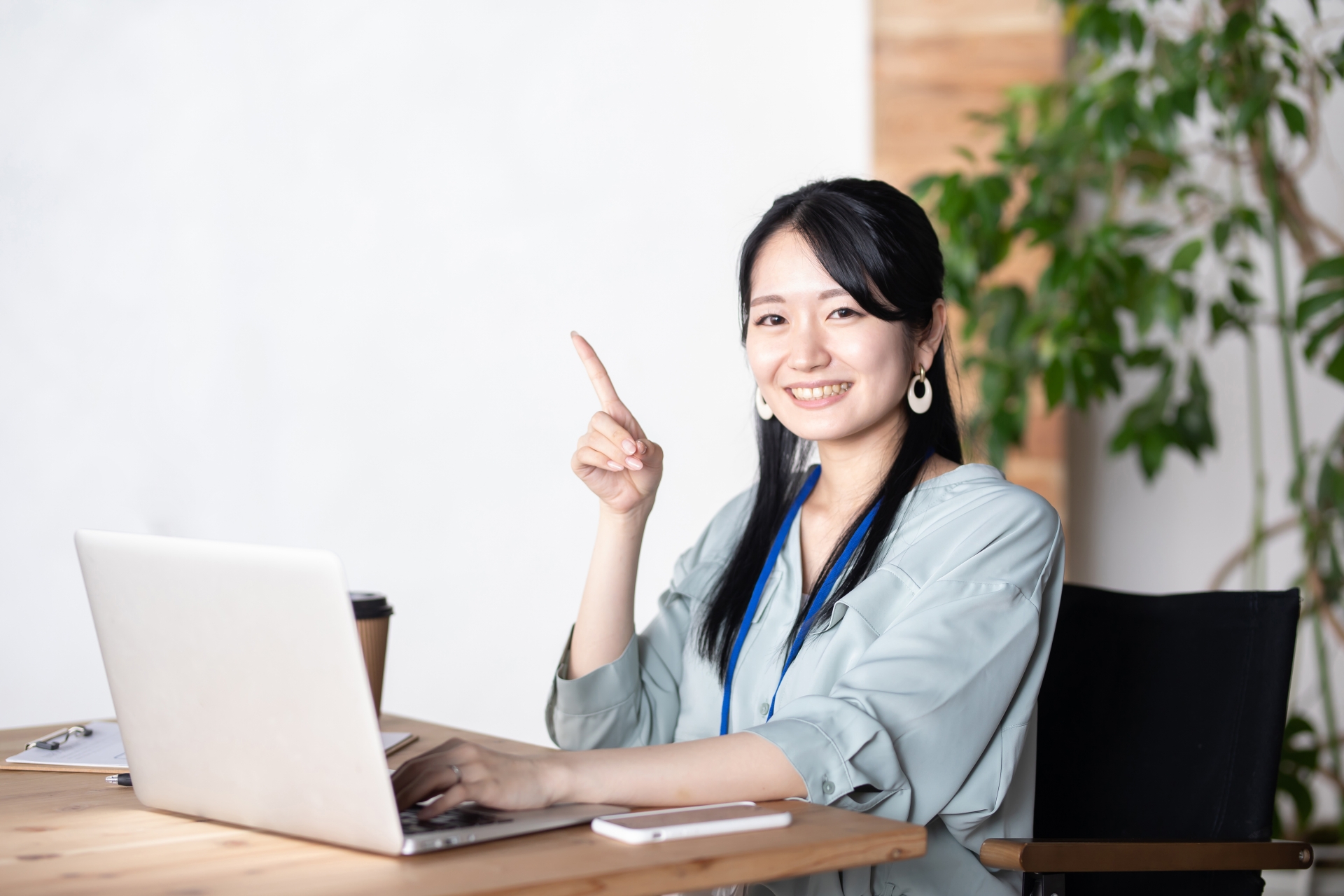 パソコンの前で指をさしほほ笑む女性