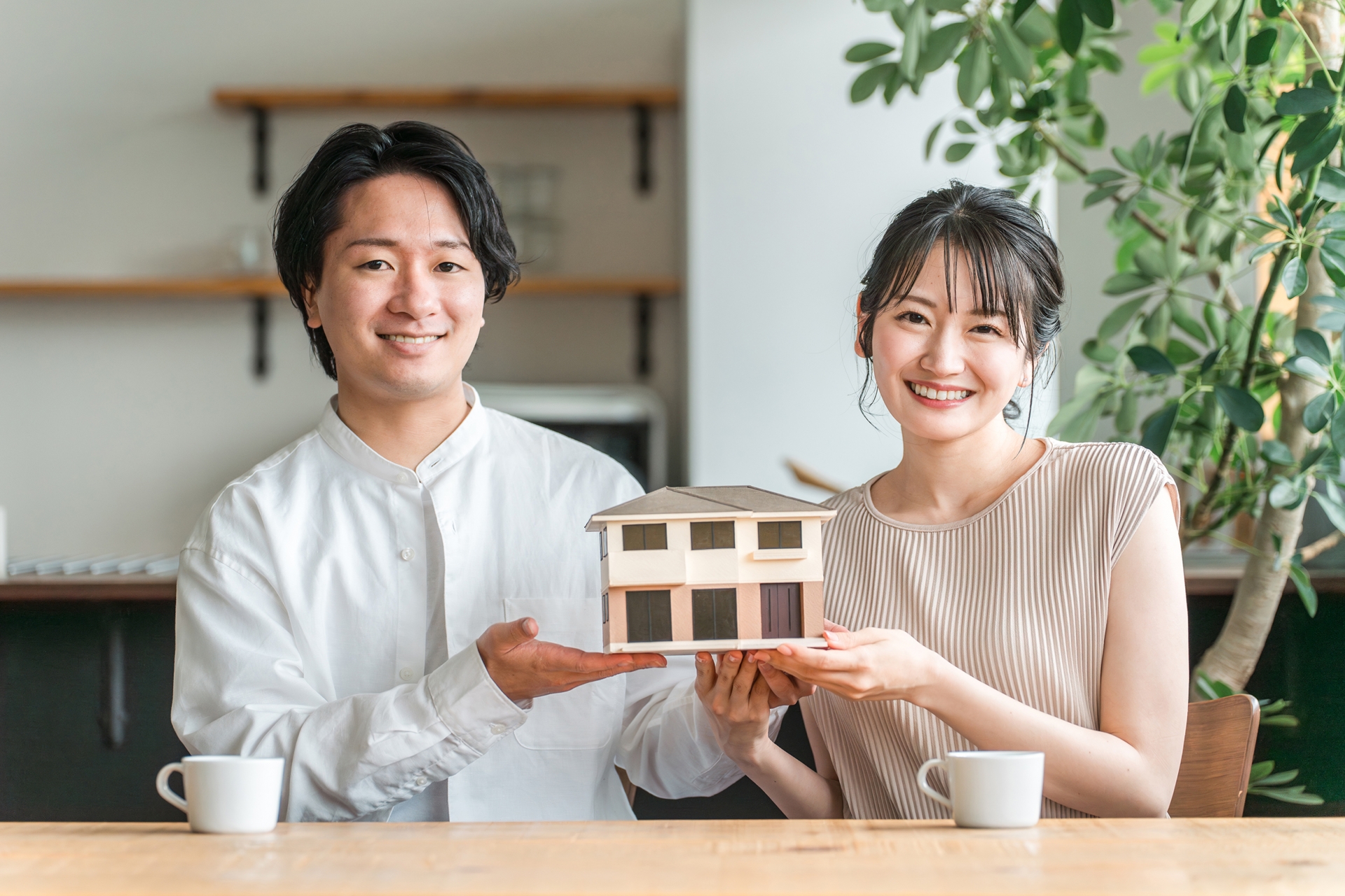 住宅模型を持ち微笑む男女
