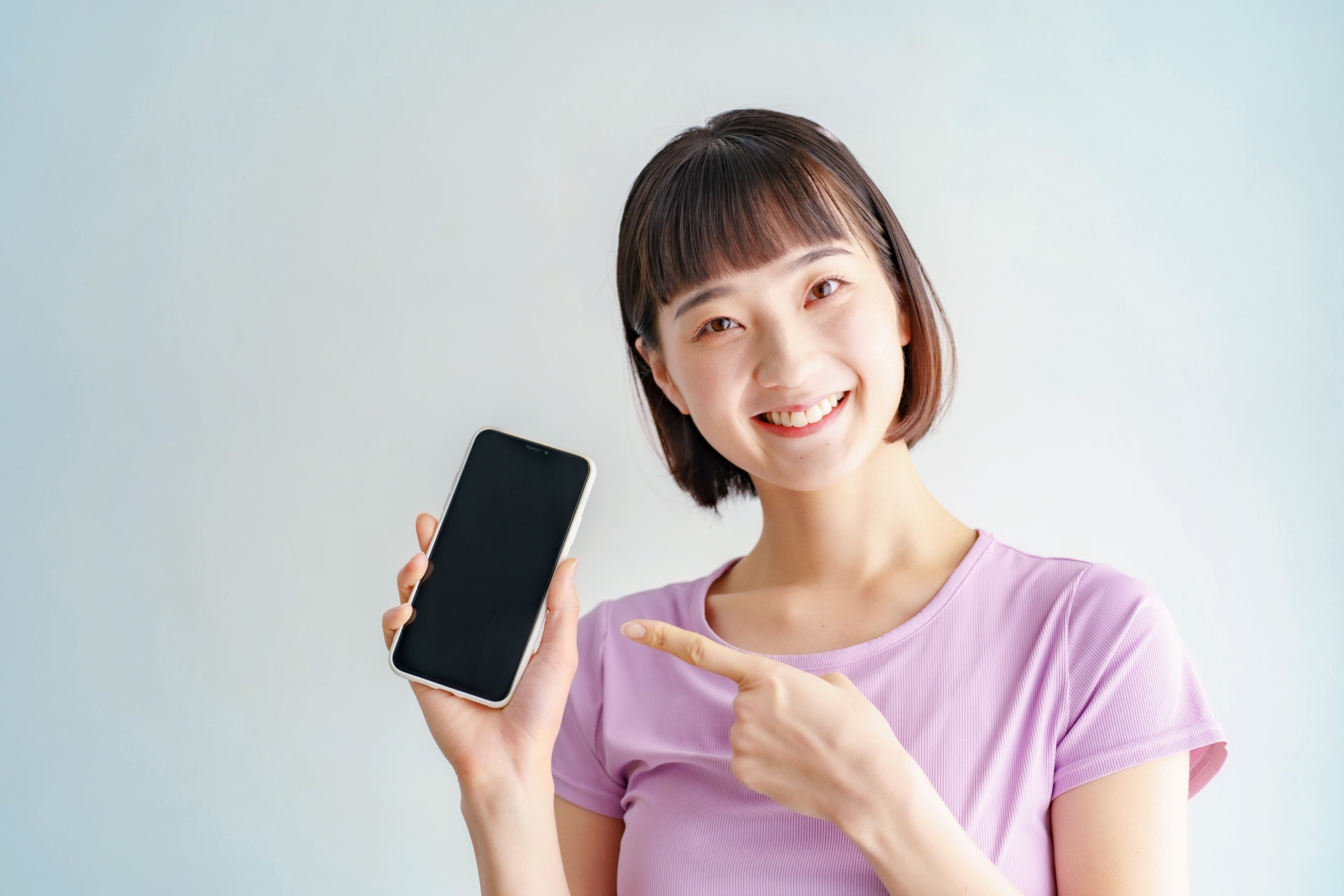 スマホを指さす女性