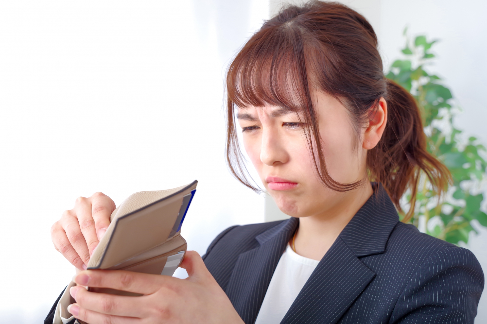 財布を見て渋い顔をする女性