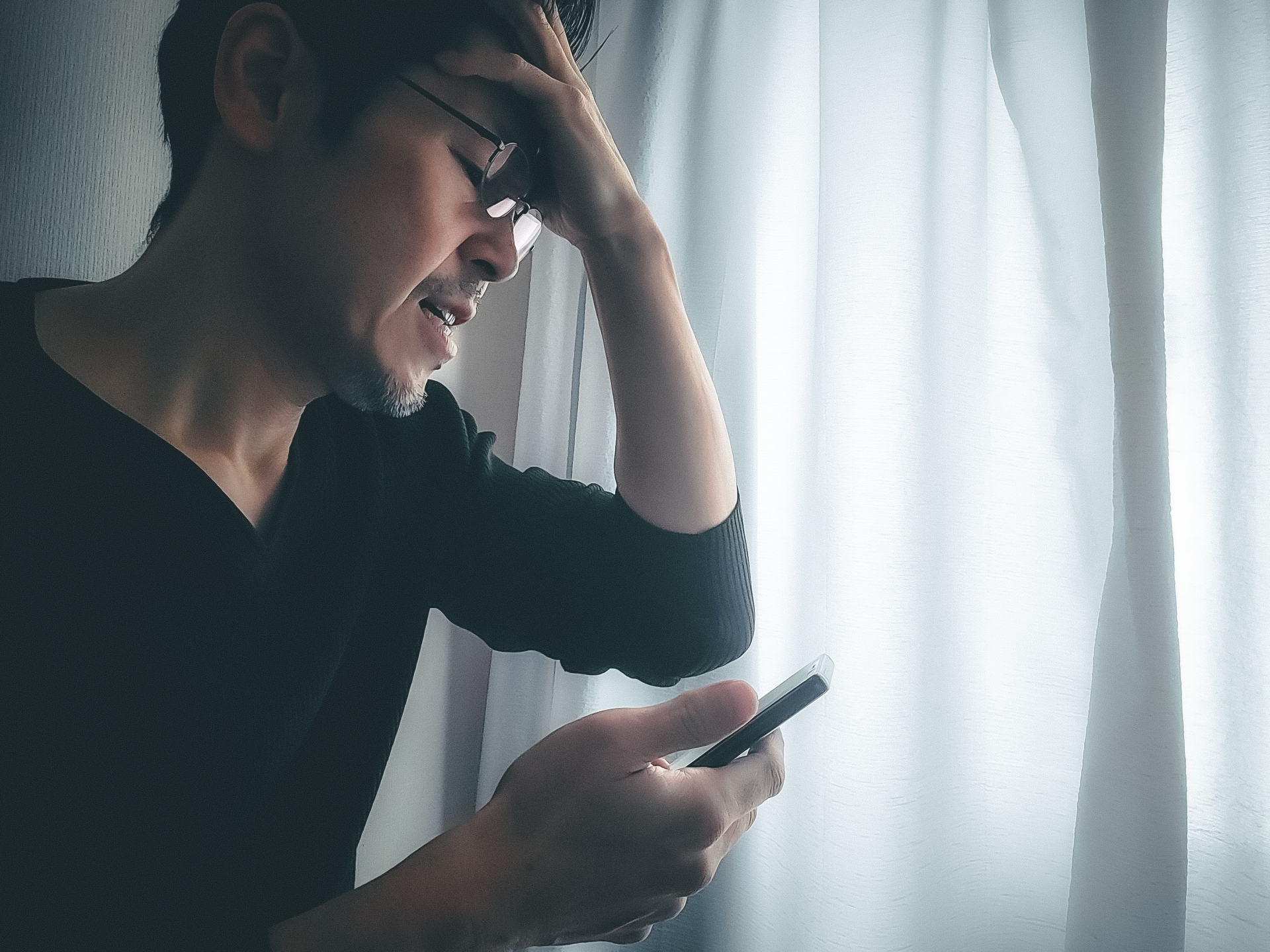 スマホをみて焦る男性