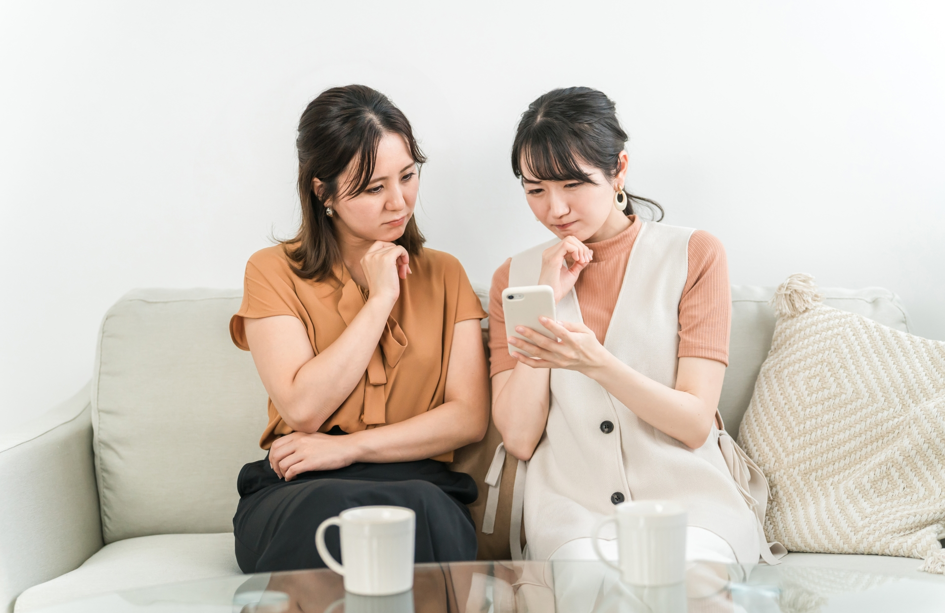 スマホを見て考え込む女性2人