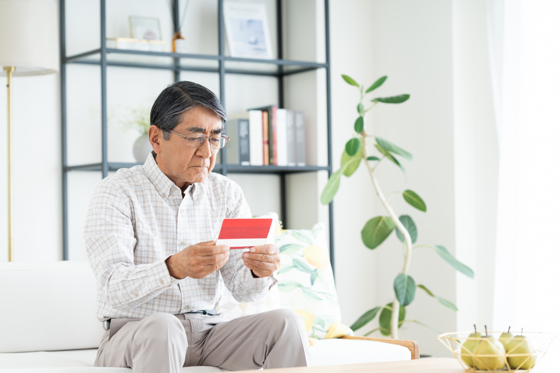 通帳を見つめる男性