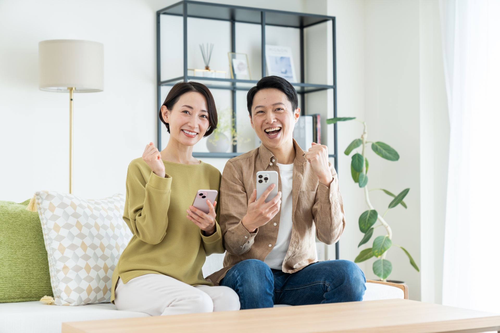 スマホを手に笑顔の男女