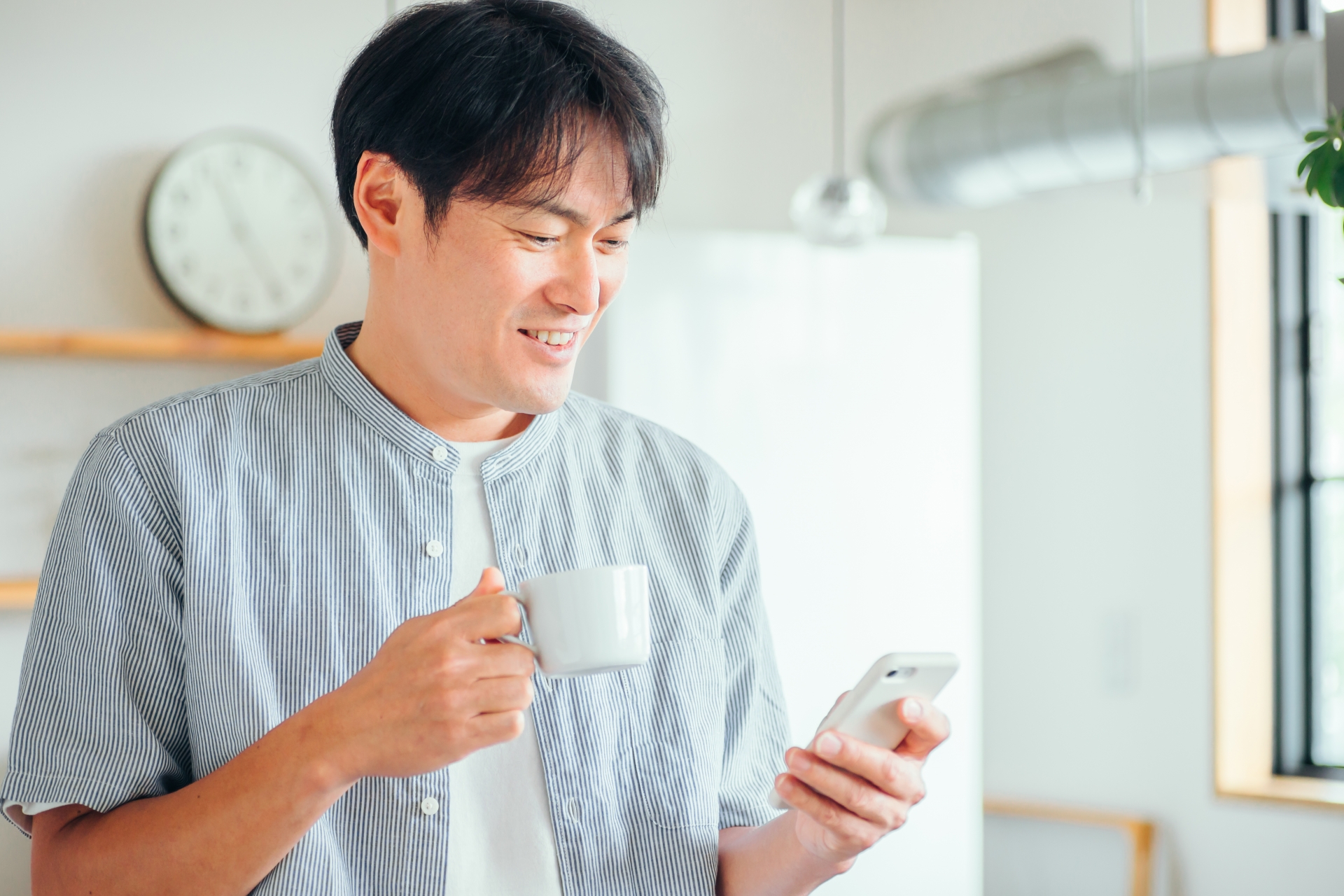 家でスマホを使う男性