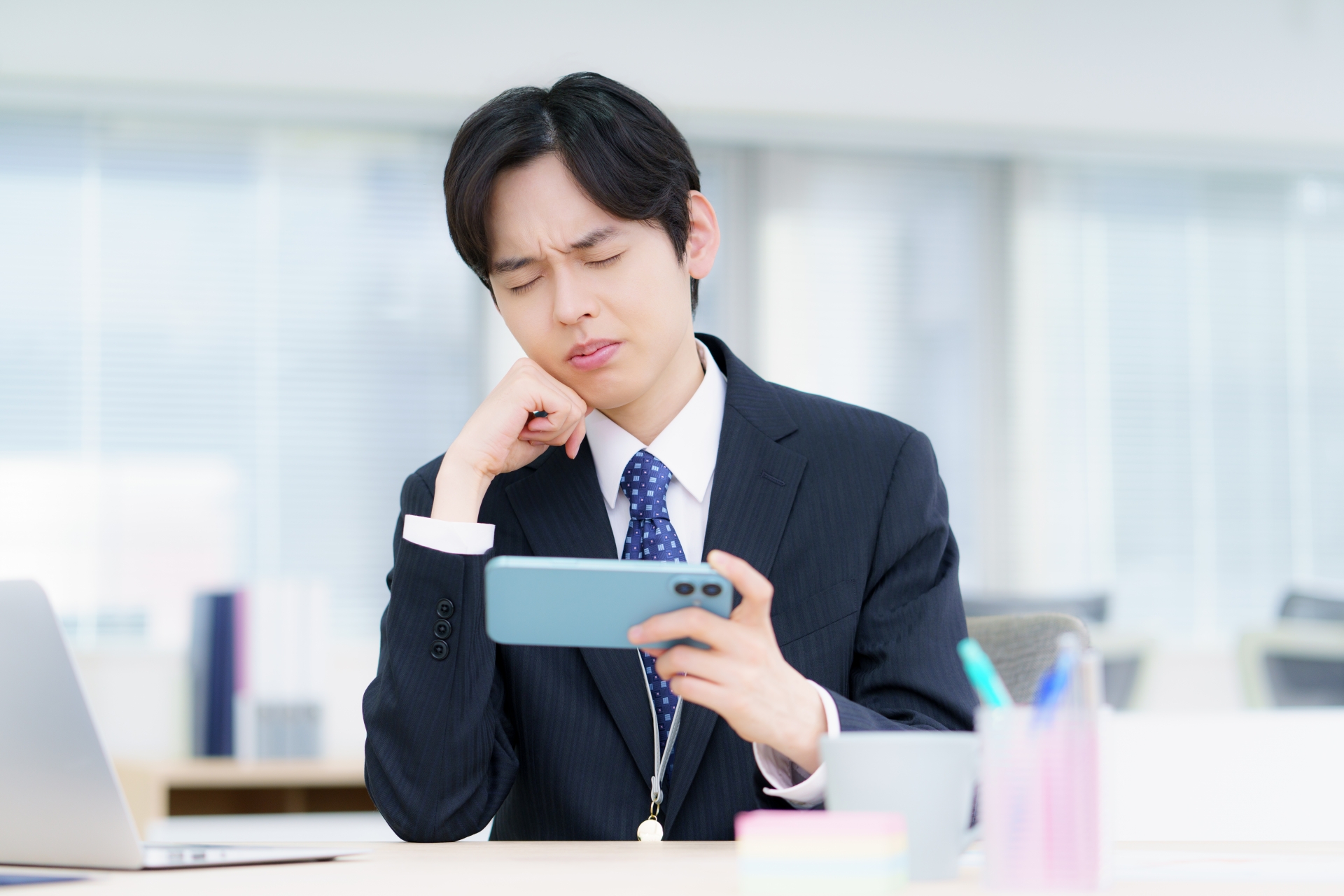 スマホを手に悩む男性