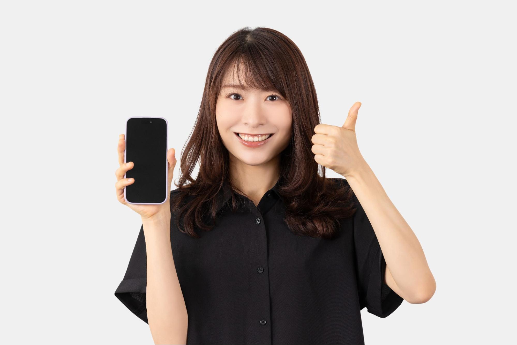 スマホを持って笑顔の女性