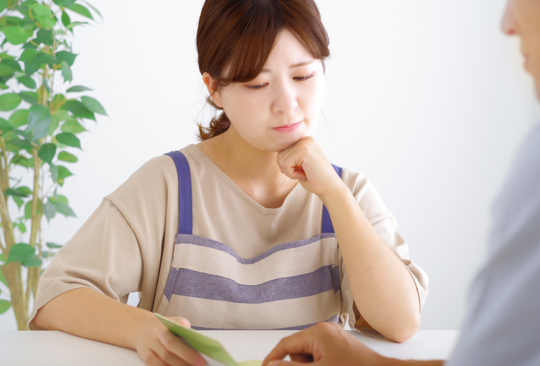 悩むエプロンをした女性