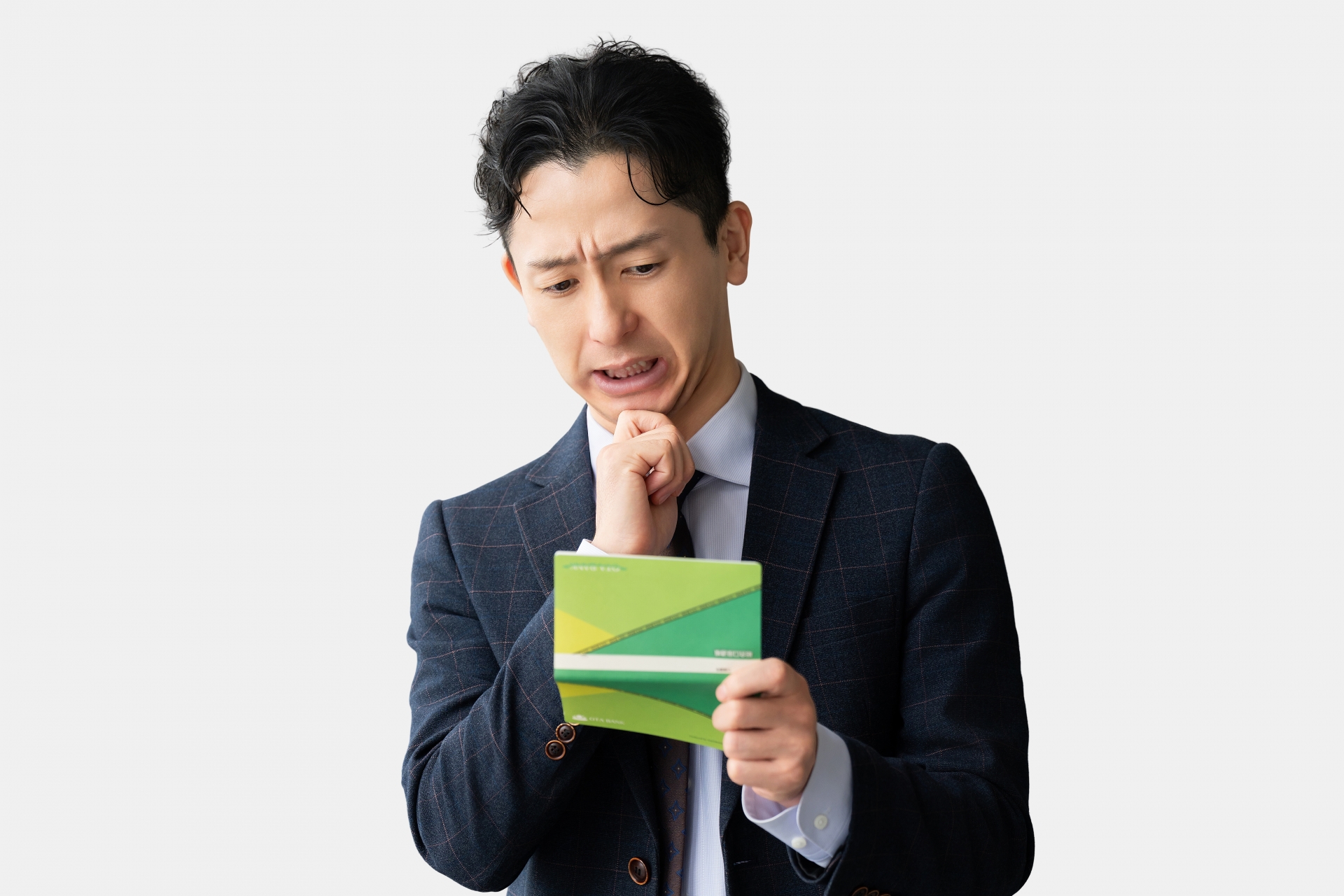 通帳を見て悩む男性