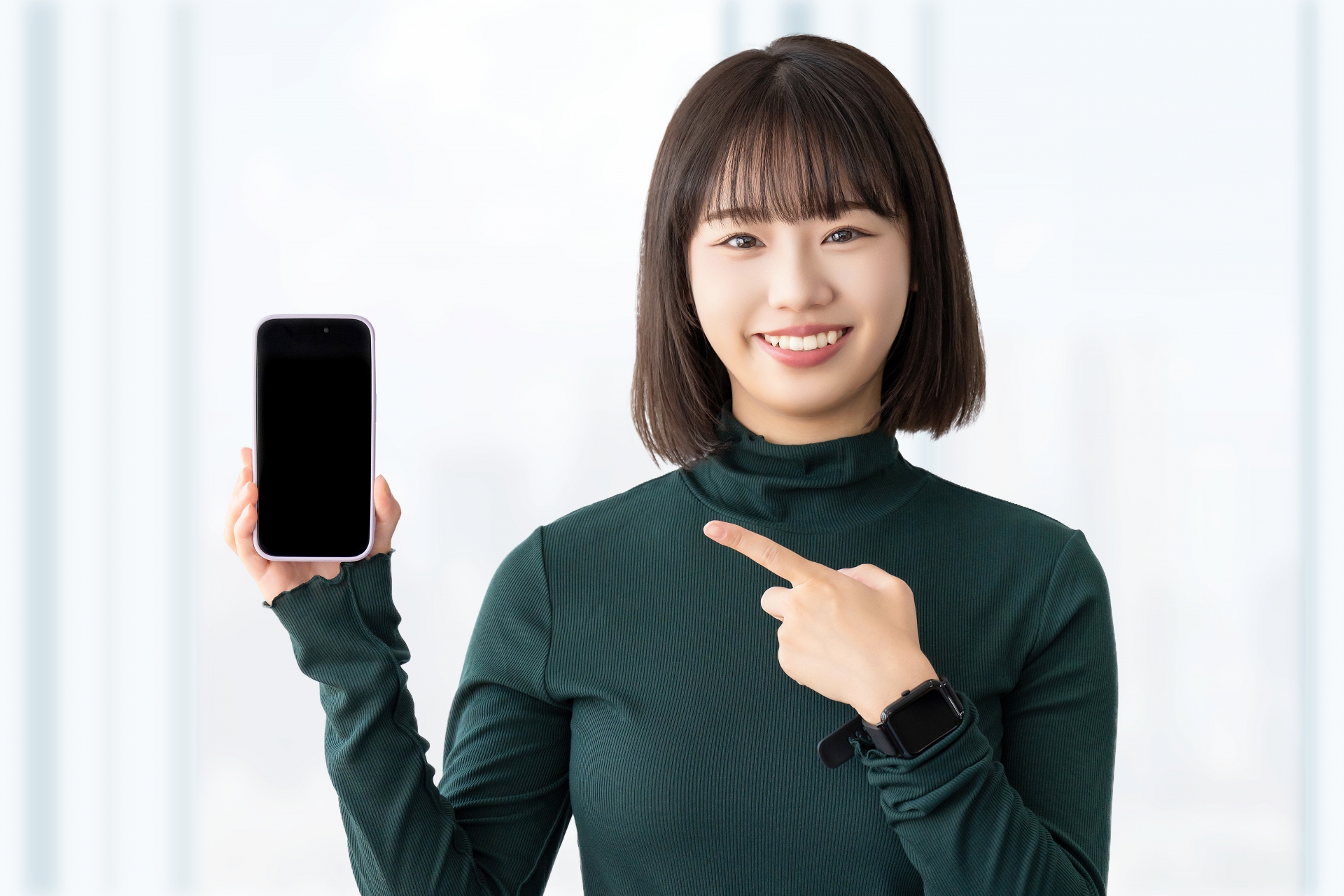 スマホを手に持ち笑顔の女性
